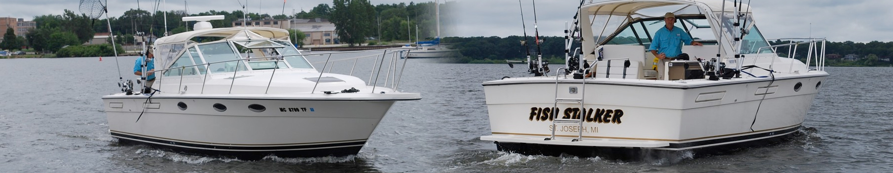 Two boats docked facing each other on calm water near a forested shore.