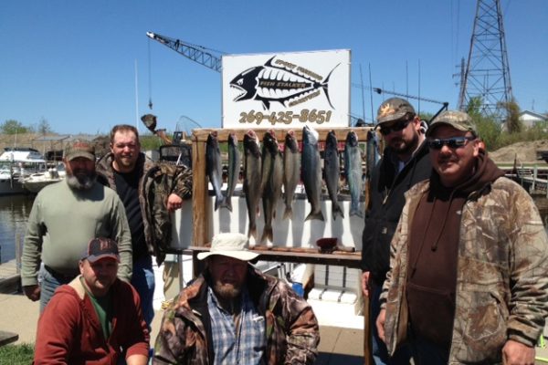 Group of fishermen proudly displaying their catch of the day.